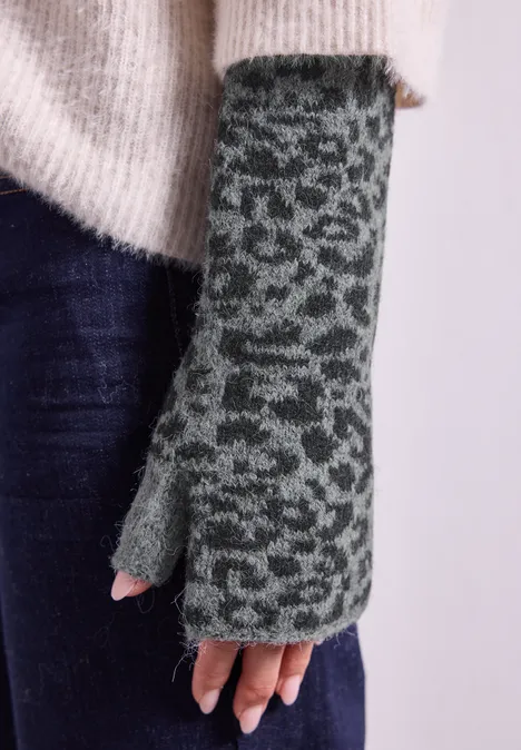 Jacquard Armwärmer mit Leo-Muster Black Eine Hand in einem gestrickten, grün-grauen, fingerlosen Handschuh mit Leopardenmuster vor weißem Hintergrund.