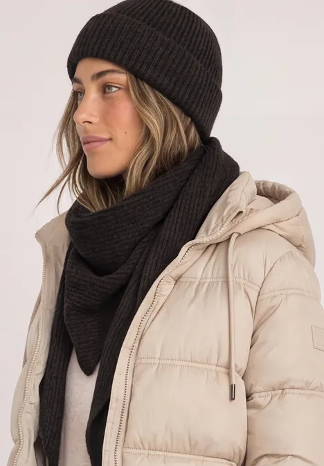 Beanie in Melange-Optik Black Frau mit schwarzer Strickmütze und passendem Schal trägt hellbeige gesteppte Winterjacke