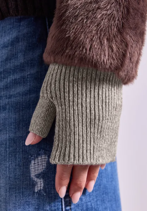 Armwärmer in Melange-Optik Muddy Mocha Gestrickter, fingerloser Handschuh an Hand, kombiniert mit flauschigem Mantelärmel und lässiger Jeans.