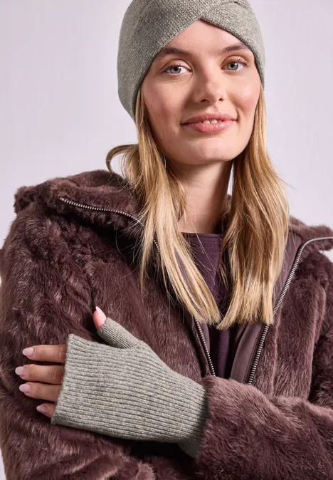 Armwärmer in Melange-Optik Muddy Mocha Junge Frau mit grauer Strickmütze und handschuhlosen Handschuhen trägt eine braune Kunstpelzjacke mit Kapuze.
