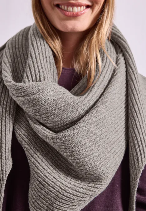 Dreiecksschal in Melange-Optik Muddy Mocha Eine lächelnde Frau trägt einen großen grauen Strickschal über einem lila Oberteil.
