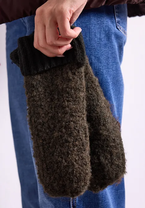 Bouclé-Mix Fäustlinge Black Eine Hand hält ein Paar braune, flauschige Fäustlinge vor blauer Jeans.