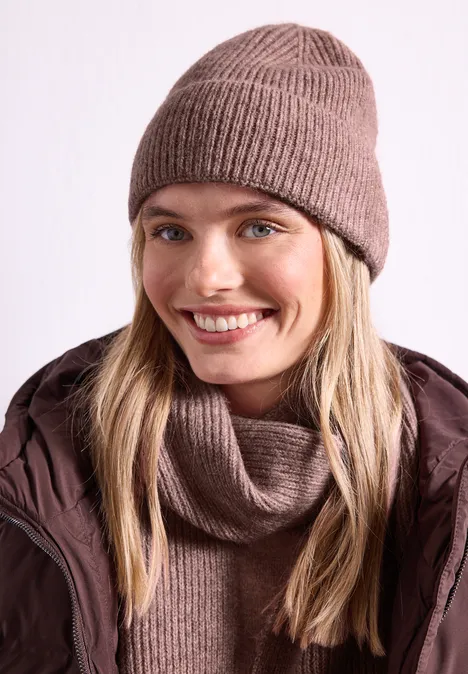 Beanie im Melange-Look vintage blush mel. Eine lächelnde Frau trägt eine braune Strickmütze, einen passenden Schal und eine gesteppte Jacke.