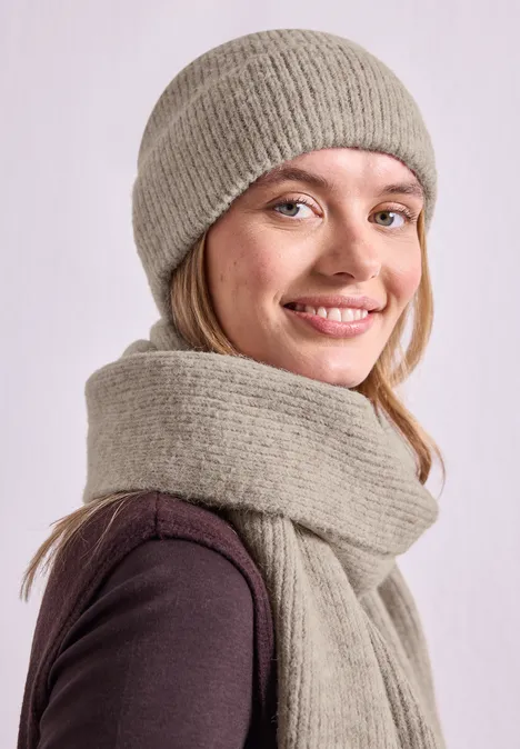 Beanie im Melange-Look barley beige mel. Lächelnde junge Frau trägt graue Strickmütze und passenden Schal.