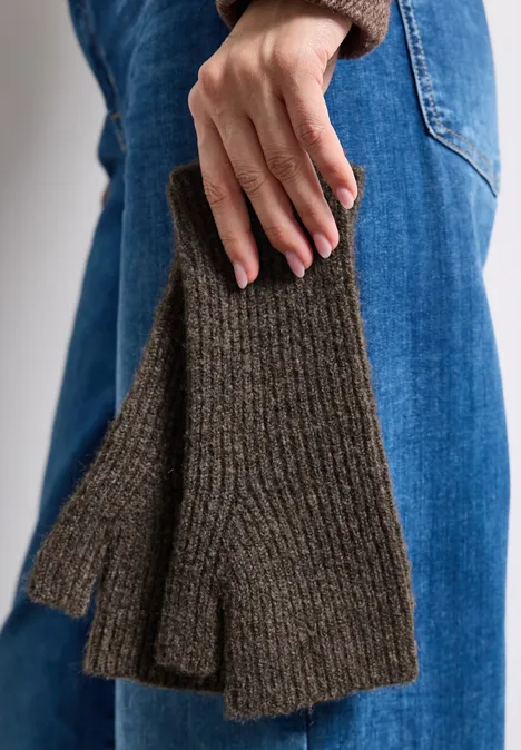 Armwärmer im Melange-Look auburn brown mel. Nahaufnahme einer Person in Jeans, die olivgrüne, gestrickte Fingerhandschuhe trägt.