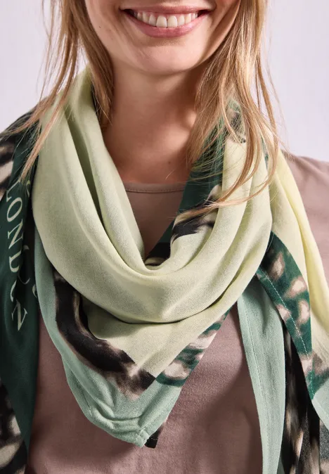Vierkante sjaal met grafische print multicolor Close-up van een glimlachende vrouw met een lichtgroene sjaal met patroon.