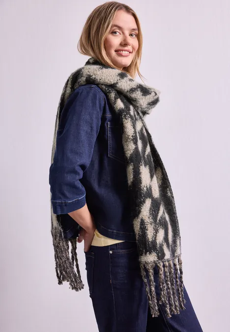 Schal mit Fransen und Leo-Muster Black Lächelnde Frau in Denim-Outfit mit langem, gemustertem Schal vor hellem Hintergrund.
