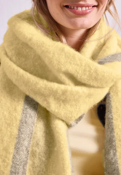 Langer Schal im Two-Tone-Look sunbeam yellow Nahaufnahme einer lächelnden Person mit flauschigem gelb-grau gestreiftem Schal