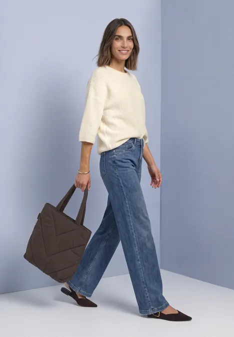 Sac cabas doublé, couleur unie auburn brown Frau im cremefarbenen Pullover, weiten Jeans und schwarzen Slippern trägt große braune Stepp-Tasche.