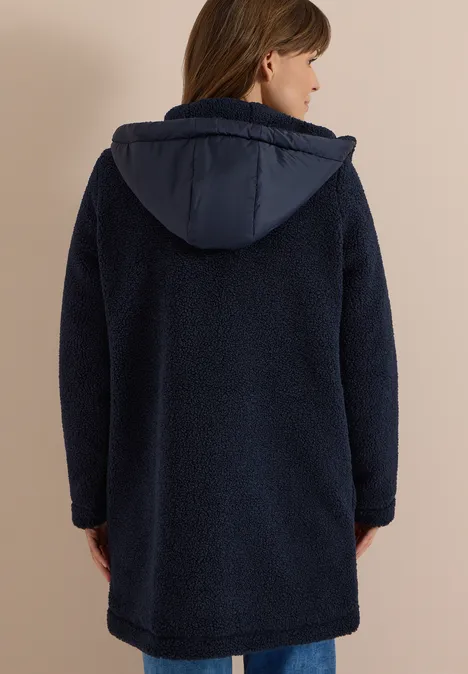 Manteau Teddy à texture contrastée avec capuche dark navy blue Frau von hinten in einem dunkelblauen, knielangen Teddy-Fleece-Mantel mit Kapuze.