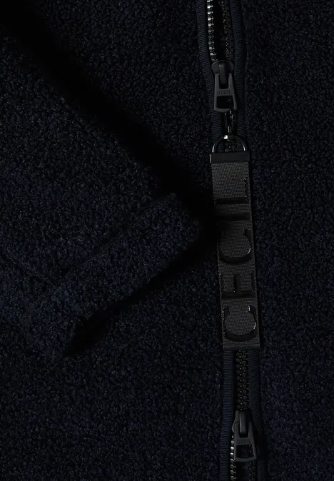 Manteau Teddy à texture contrastée avec capuche dark navy blue Nahaufnahme eines schwarzen Reißverschlusses an dunkelblauem Fleece-Stoff.