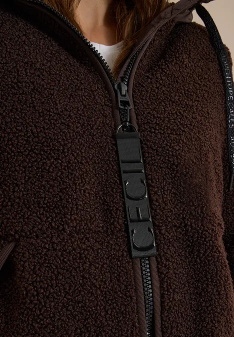 Strukturmix Teddy-Mantel mit Kapuze chocolate sauce brown Nahaufnahme einer braunen Teddy-Fleecejacke mit auffälligem schwarzem Reissverschluss-Zipper