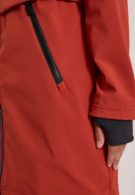 Nahaufnahme einer roten Jacke mit seitlicher Reißverschlusstasche und schwarzem Innenärmelbund