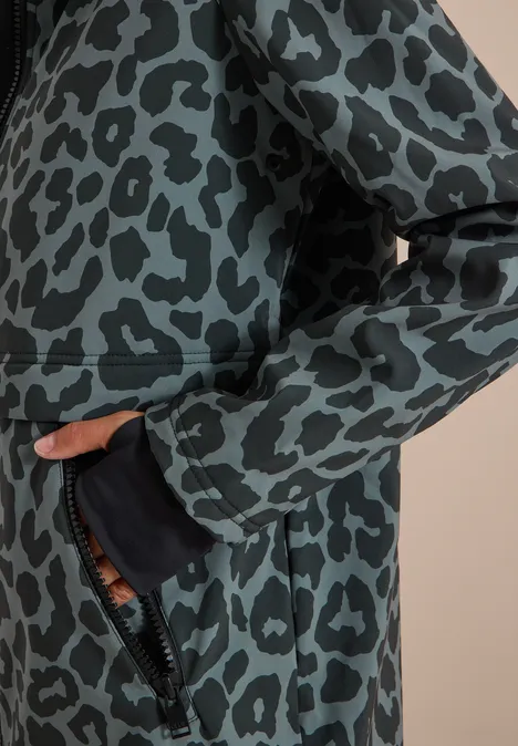 Gros plan sur un manteau vert imprimé léopard noir avec poche latérale