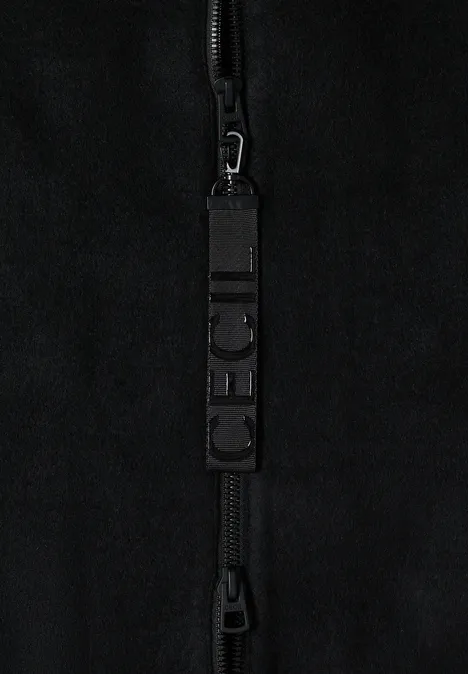 Schwarzer Reißverschluss an schwarzem Stoff mit markantem Zipper-Anhänger 'CECIL'.