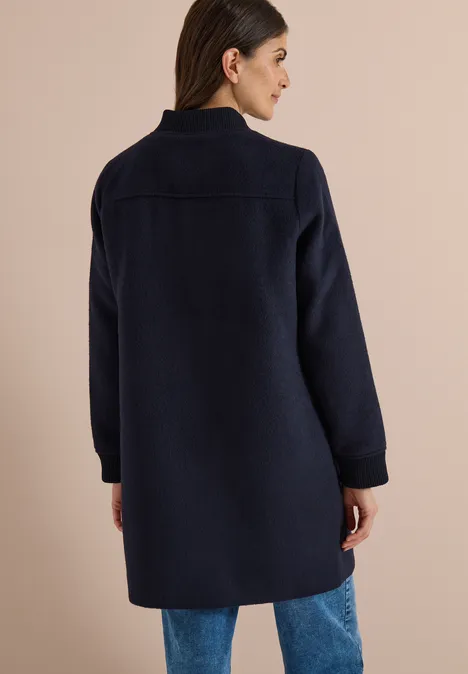 Langer Blouson mit Wollanteil dark navy blue Frau von hinten in dunkelblauem, knielangem Mantel kombiniert mit Jeans.