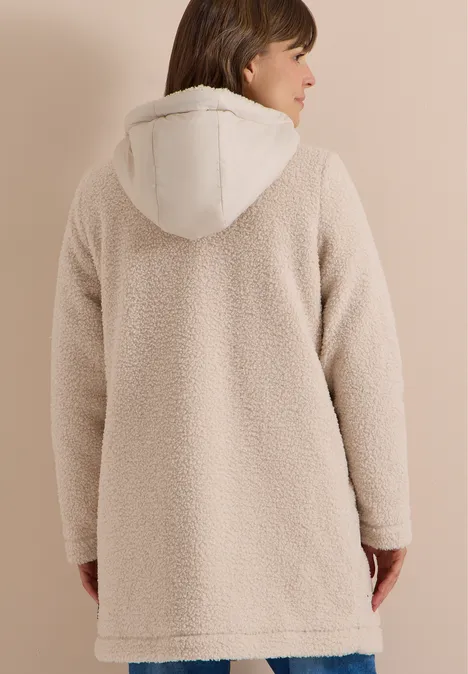 Strukturmix Teddy-Mantel mit Kapuze teddy vanilla white Eine Person von hinten trägt einen cremefarbenen Teddy-Mantel mit Kapuze vor neutralem Hintergrund.