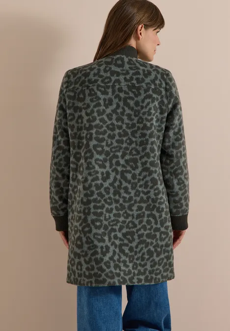 Langer Blouson mit Wollanteil olive night Frau steht mit dem Rücken zur Kamera und trägt einen knielangen, grünen Leopardenmantel zu Jeans.