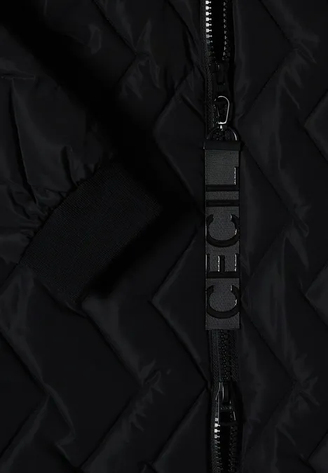 Nahaufnahme einer schwarzen Steppjacke mit Reißverschluss und bedrucktem Zipper-Anhänger