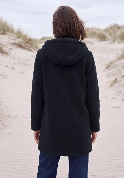 Mantel in angerauter Wolloptik dark navy blue Eine Person mit schwarzem Kapuzenmantel steht auf Sanddünen, Rücken zum Betrachter.