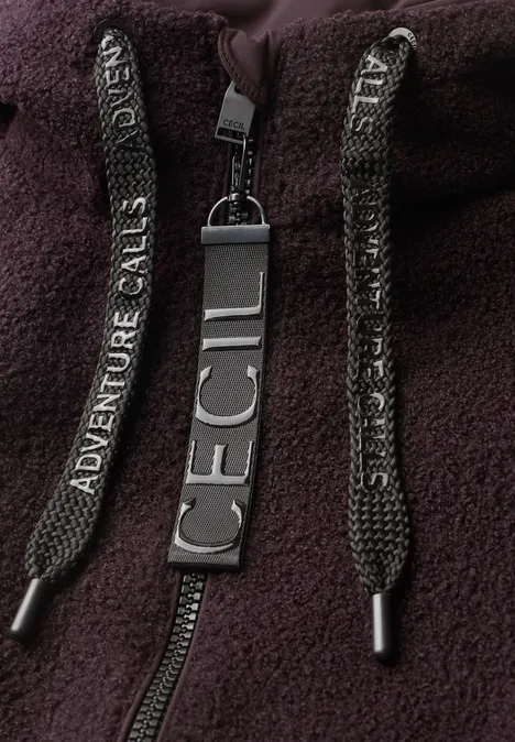 Jas met een ruwe wollook berry red Close-up van een donkerpaars fleece-hoodie met 'Adventure Calls'-koorden en 'ICECI'-label.