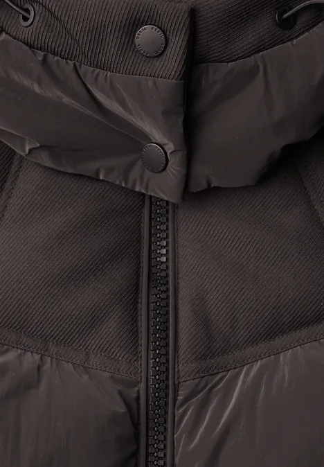 Nahaufnahme eines schwarzen Winterjackenausschnitts mit Reißverschluss und Druckknöpfen.