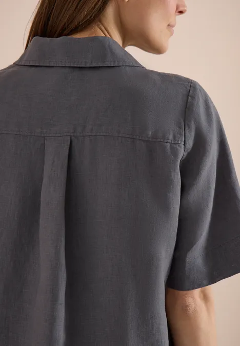 Rugaanzicht van een persoon met een grijs, kort mouw shirt