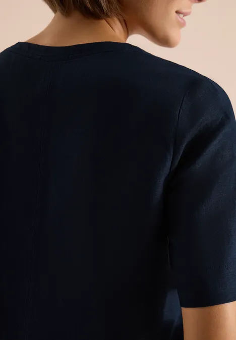 Rugaanzicht van een persoon in een donkerblauw T-shirt met korte mouwen en ronde hals.