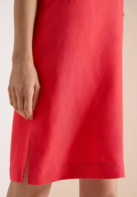 Rotes Kleid mit seitlichem Schlitz, sichtbar von der Taille bis knapp unter das Knie.