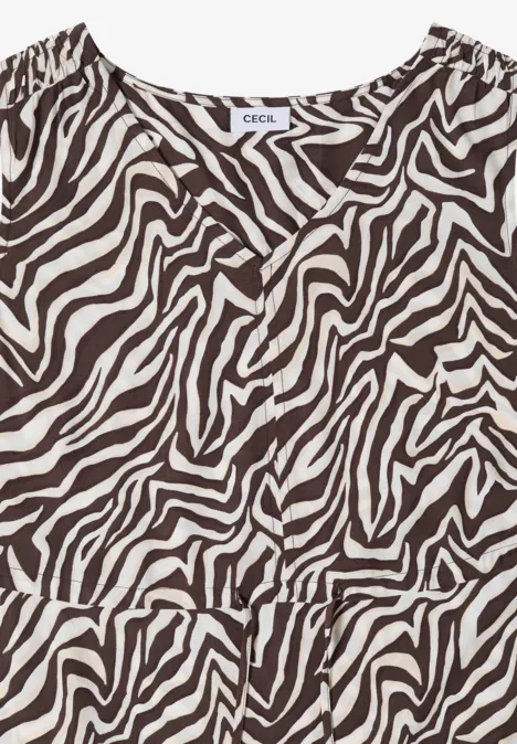 Mouwloze, getailleerde top met bruin-witte zebradessin en subtiele volant aan de zoom.