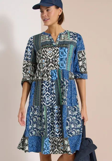 Robe mi-longue patchwork bleu et vert à motifs, manches trois-quarts, taille cintrée.