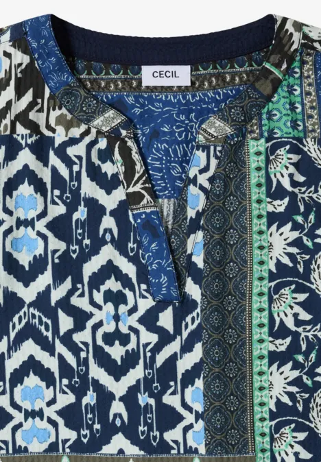 Haut bleu-blanc-vert à motifs géométriques et floraux, encolure en V avec fente, étiquette "Cecil".