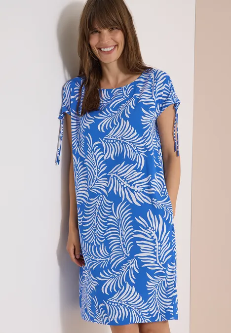 Knielanges Kleid mit Capsleeves surf blue Eine Frau trägt ein knielanges hellblaues Kleid mit weißen Blattmustern und kurzen Ärmeln.