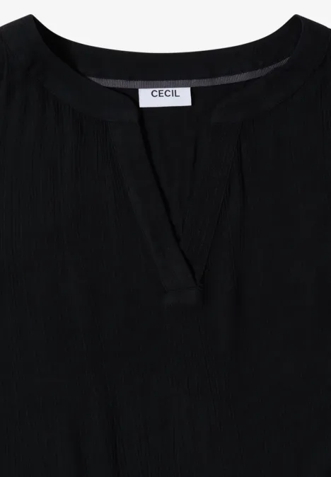 Zwarte damestop met subtiele split bij de ronde hals en CECIL-label.