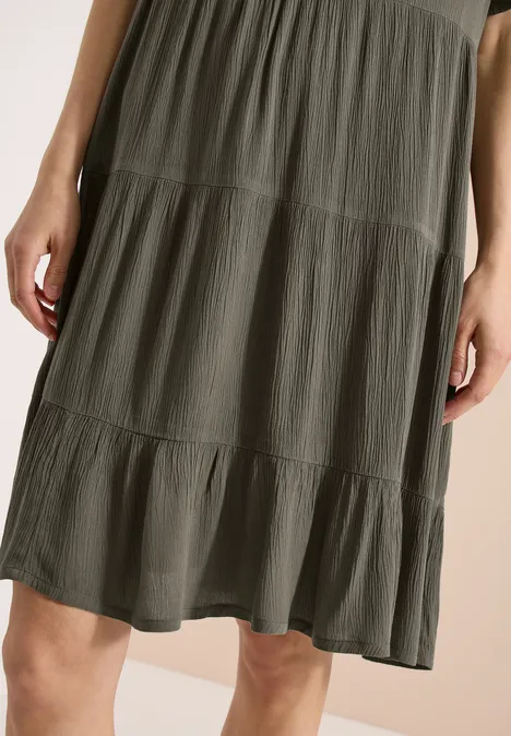 Halflange, olijfgroene jurk met volantlagen, luchtig en soepel vallend.