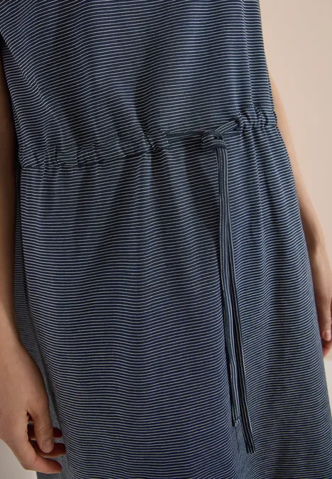 Close-up van een blauw gestreepte jurk met taillekoord en steekzakken.