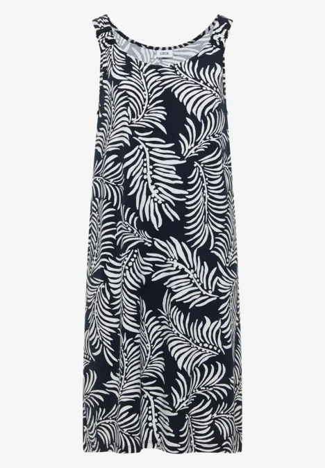 Mouwloze maxi-jurk met wit bladmotief op een donkere achtergrond.