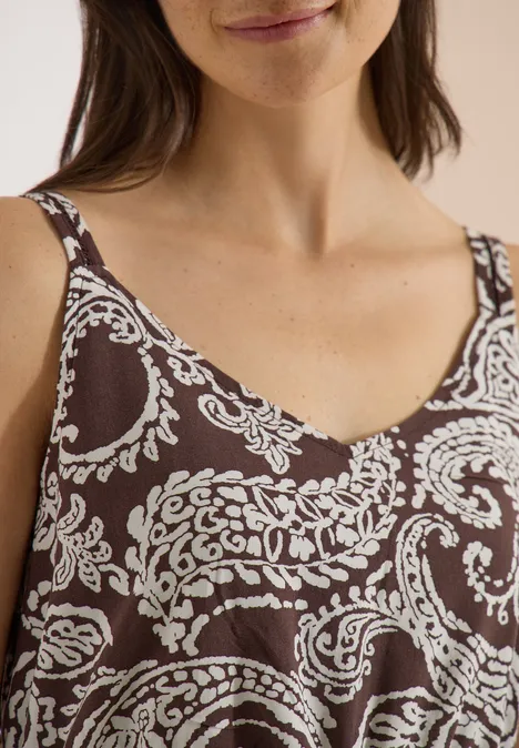 Maxikleid mit V-Neck und Print brown cacao Nahaufnahme einer Frau in einem braunen ärmellosen Top mit weißem Paisley-Muster und V-Ausschnitt.