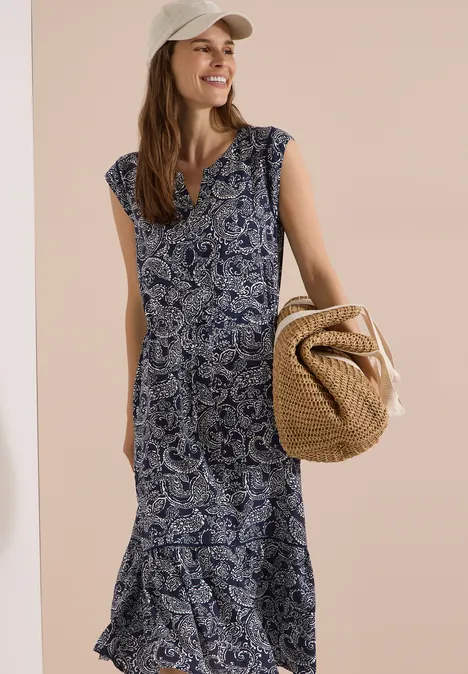 Midikleid mit Split Neck und Print universal blue Frau in ärmellosem, blau-weiß gemustertem Midikleid mit V-Ausschnitt und Strohtasche.