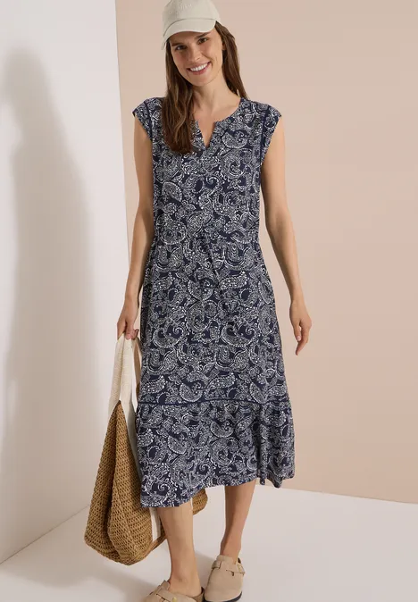 Midikleid mit Split Neck und Print universal blue Model trägt ärmelloses Midikleid mit blau-weißem Paisleymuster, V-Ausschnitt, Korbtasche und Sandalen.