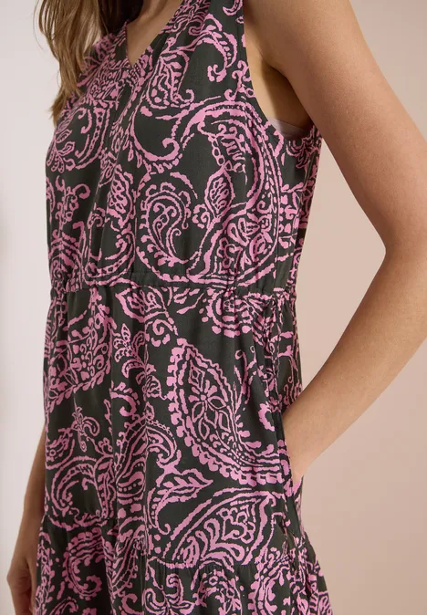 Midikleid mit V-Neck und Print raw khaki Eine Frau trägt ein ärmelloses Kleid mit pinkem Paisley-Muster auf dunklem Stoff.