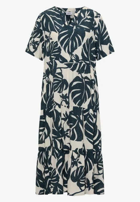 Robe mi-longue à col fendu et imprimé palm breeze green Robe longue à manches courtes blanche à motif de feuilles noires.