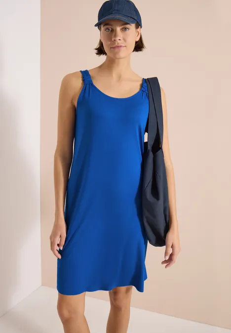 Knielanges Kleid mit Knotendetail surf blue Person in ärmellosem, knielangem, blauem Kleid mit schwarzer Umhängetasche vor schlichtem Hintergrund.