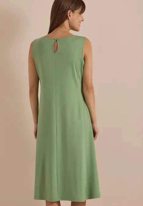 Rückenansicht einer Frau in ärmellosem, knielangem, olivgrünem Kleid mit kleinem Rückenausschnitt.