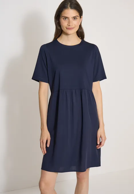 Knielanges Kleid mit Strukturmix urban dark blue Eine Frau trägt ein schlichtes, dunkelblaues, knielanges Kleid mit kurzen Ärmeln