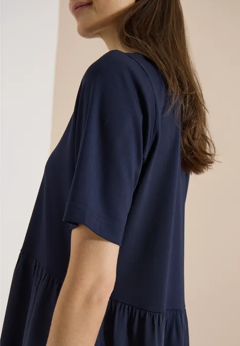 Knielanges Kleid mit Strukturmix urban dark blue Frau in locker sitzendem dunkelblauem T-Shirt vor hellem Hintergrund