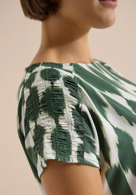 Knielanges Kleid mit Capsleeves und Print vanilla white Nahaufnahme eines grün-weißen Batik-Shirts mit Schulterraffung