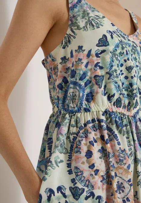 Ein ärmelloses, leichtes Sommerkleid mit pastellfarbenem Paisley-Blumenmuster und seitlicher Eingrifftasche.