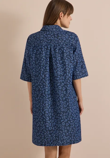 Kniehoge jurk met luipaardprint Dark blue wash Vrouw van achteren in een losse blauwe overhemdjurk met korte mouwen en subtiel dessin.