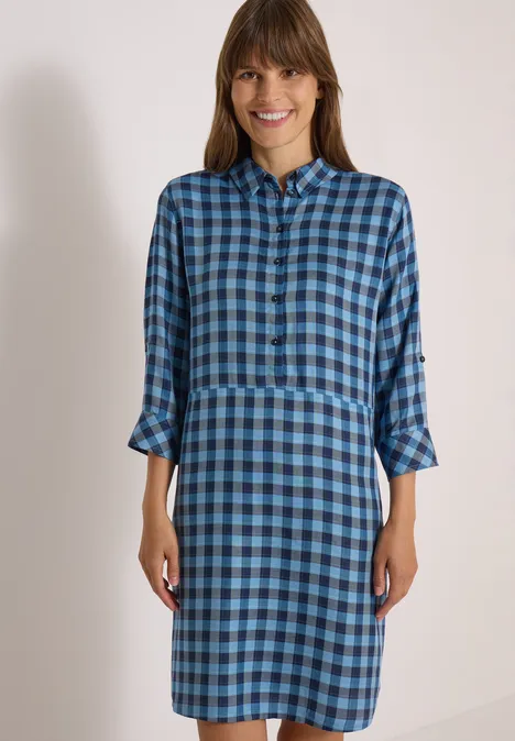 Knie-lange jurk met een fijn ruitjespatroon easy blue Eine lächelnde Frau trägt ein blau kariertes Hemdkleid mit 3/4-Ärmeln und Kragen.